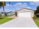 Inviting home featuring a well-kept lawn, spacious driveway, and an attached two-car garage at 803 Camino Del Rey Dr, The Villages, FL 32159