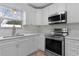 Modern kitchen featuring stainless steel appliances, sleek white countertops, and tile backsplash at 803 Camino Del Rey Dr, The Villages, FL 32159