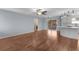 Bright living room with hardwood floors, sliding glass doors, and a seamless transition to the kitchen area at 803 Camino Del Rey Dr, The Villages, FL 32159