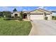 Charming single-story home featuring a well-maintained lawn, two car garage, and lush landscaping at 815 Forest Breeze Path, Leesburg, FL 34748