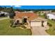 Inviting single-story home with a well-manicured lawn, neutral paint scheme, and a two car garage at 815 Forest Breeze Path, Leesburg, FL 34748