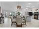 Open-concept dining area with stylish lighting fixture, table setting, and view into living spaces at 8194 Se 177Th Winterthur Loop, The Villages, FL 32162