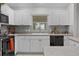 Bright kitchen featuring white cabinets, black appliances, and a mosaic tile backsplash at 8194 Se 177Th Winterthur Loop, The Villages, FL 32162