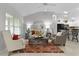 Cozy living room featuring a large window, comfortable seating, and a stylish area rug at 8194 Se 177Th Winterthur Loop, The Villages, FL 32162