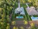 Stunning aerial view of a luxury home with a backyard pool surrounded by lush landscaping and mature trees at 16909 Crete Way, Bella Collina, FL 34756