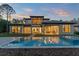 Gorgeous modern home with a backyard pool, covered patio, and open living spaces visible through large windows at 16909 Crete Way, Bella Collina, FL 34756