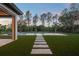 Inviting backyard oasis with a modern pool, lush artificial turf, and stepping stone pathway to the home at 16909 Crete Way, Bella Collina, FL 34756