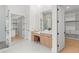 Bright modern bathroom with separate vanities, glass shower, and walk-in closet at 16909 Crete Way, Bella Collina, FL 34756
