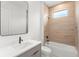 Modern bathroom featuring wood tile accents, black trim mirror, and gray cabinets at 16909 Crete Way, Bella Collina, FL 34756