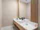 Modern powder room featuring a floating vanity, vessel sink, waterfall faucet, and stylish decorative mirror at 16909 Crete Way, Bella Collina, FL 34756