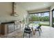 Indoor dining area with a modern outdoor kitchen and views of the backyard pool at 16909 Crete Way, Bella Collina, FL 34756