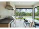 Indoor dining area with outdoor kitchen, unique hanging chair and backyard pool view at 16909 Crete Way, Bella Collina, FL 34756