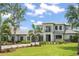 Well-manicured lawn leads to a beautiful two-story home with a three-car garage and paver driveway at 16909 Crete Way, Bella Collina, FL 34756