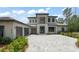 Beautiful two-story home with a grand entrance, three-car garage, and meticulously laid paver driveway at 16909 Crete Way, Bella Collina, FL 34756