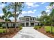 Elegant two-story home featuring a paver driveway, well-maintained landscaping, and attached three-car garage at 16909 Crete Way, Bella Collina, FL 34756