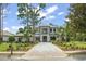 Elegant two-story home featuring a paver driveway, well-maintained landscaping, and attached three-car garage at 16909 Crete Way, Bella Collina, FL 34756