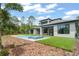 Modern home exterior with a backyard pool and spa, surrounded by lush landscaping and manicured lawn at 16909 Crete Way, Bella Collina, FL 34756