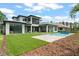 Expansive backyard featuring a modern home with a pool, lush lawn, and inviting outdoor living spaces at 16909 Crete Way, Bella Collina, FL 34756