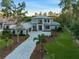 Impressive two-story home boasts a manicured lawn, lush landscaping, and an expansive driveway leading to a three-car garage at 16909 Crete Way, Bella Collina, FL 34756