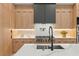 This modern kitchen offers stainless steel appliances, custom wood cabinets, and quartz countertops on the kitchen island at 16909 Crete Way, Bella Collina, FL 34756