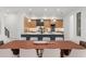 The gourmet kitchen features wooden cabinetry, a long dining table, and pendant lighting over the marble countertops at 16909 Crete Way, Bella Collina, FL 34756