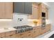 A designer kitchen shows a stainless steel gas cooktop, custom wood cabinets, and quartz countertops at 16909 Crete Way, Bella Collina, FL 34756