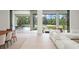 Bright, open living room with access to the outdoor pool area and furnished with a plush white sofa at 16909 Crete Way, Bella Collina, FL 34756