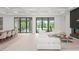 Bright living room featuring coffered ceilings, expansive windows, modern fireplace, and dining area at 16909 Crete Way, Bella Collina, FL 34756