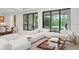 A well-lit living room features a plush sectional sofa and views of the pool and backyard through sliding glass doors at 16909 Crete Way, Bella Collina, FL 34756