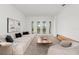 Bright, modern living room with neutral color palette, plush seating, and access to balcony at 16909 Crete Way, Bella Collina, FL 34756