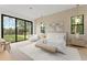 Bright main bedroom with a large sliding glass door, contemporary decor, and outdoor views at 16909 Crete Way, Bella Collina, FL 34756