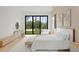 Bright main bedroom with a large sliding glass door, contemporary decor, and outdoor views at 16909 Crete Way, Bella Collina, FL 34756