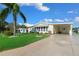 Charming single-story home featuring a well-maintained lawn, mature palm tree, and convenient covered carport at 1704 Pebble Beach Ln, Lady Lake, FL 32159