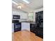 Well-lit kitchen features a ceiling fan, granite countertops, and black appliances at 1704 Pebble Beach Ln, Lady Lake, FL 32159