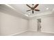 Neutral bedroom featuring a tray ceiling with fan and an arched doorway at 210 Westcott Ct, Deland, FL 32724