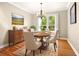 Bright dining room features hardwood floors and classic chandelier over an oval wood table set for six at 210 Westcott Ct, Deland, FL 32724