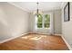 Bright dining room features hardwood floors, large window for natural light, and classic chandelier at 210 Westcott Ct, Deland, FL 32724