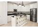 Kitchen boasts white cabinets, black countertops, stainless appliances, and an island with decorative tile at 210 Westcott Ct, Deland, FL 32724