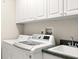 Bright laundry room with new appliances, overhead cabinets, and a utility sink at 210 Westcott Ct, Deland, FL 32724