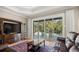 Comfortable living room with hardwood floors, built-in entertainment center, and view of screened pool area at 210 Westcott Ct, Deland, FL 32724