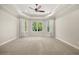 Spacious main bedroom with plush carpet, tray ceiling, and a large bay window at 210 Westcott Ct, Deland, FL 32724