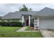 Single story home with attached garage, red front door and well-maintained lawn at 7807 Rollingridge Ct, Orlando, FL 32835