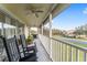 Relaxing screened balcony with rocking chairs, fan, and grill, perfect for outdoor enjoyment and neighborhood views at 5279 Bowline Ct, Oxford, FL 34484