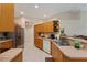 A well-lit kitchen features wooden cabinets, stainless steel appliances, and tile flooring at 5279 Bowline Ct, Oxford, FL 34484