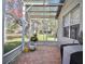 Enclosed patio with brick floors offers a relaxing outdoor space overlooking the landscaped yard at 119 Crescent Moon Dr, Groveland, FL 34736