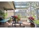 Covered patio with brick floors creates an inviting outdoor area surrounded by lush landscaping at 119 Crescent Moon Dr, Groveland, FL 34736