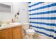 Bathroom features toilet, shower with blue-and-white striped curtain, and vanity with cabinet at 1836 Ridge Valley St, Clermont, FL 34711