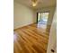 Bright bedroom features gleaming hardwood floors and sliding doors to the screened lanai at 24124 Robinwood St, Leesburg, FL 34748