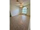 Spacious bedroom with neutral paint, tile floors, a ceiling fan, and natural light from an arched window at 24124 Robinwood St, Leesburg, FL 34748