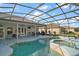 The covered patio overlooks the beautiful pool with attached hot tub at 24124 Robinwood St, Leesburg, FL 34748
